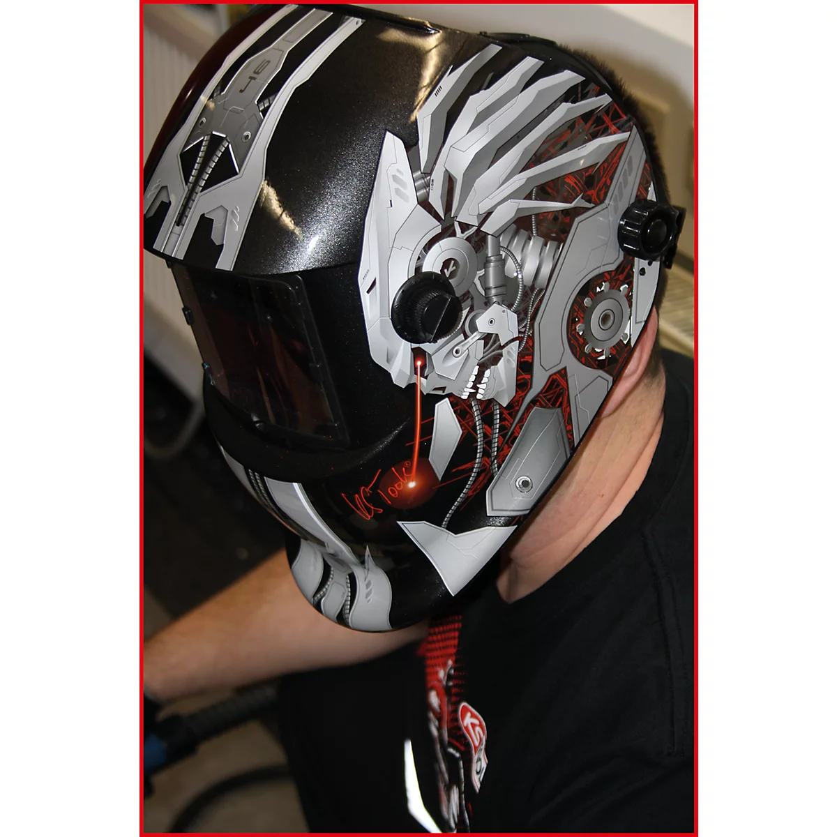 Roboter-Schweißhelm mit futuristischem Design. Schwarze und silberne Elemente mit roter Akzentuierung. Detailreiche Darstellung.